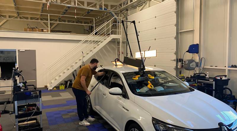 “Technicien effectuant un débosselage sans peinture sur une voiture”